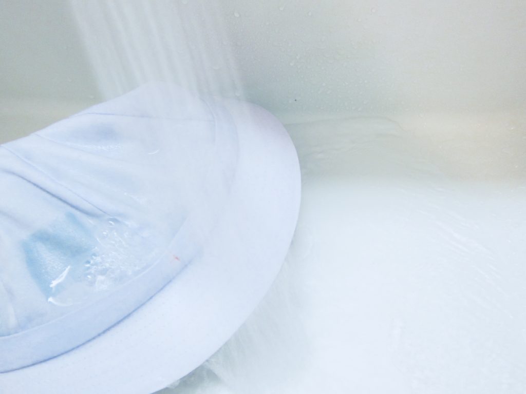 白い帽子をお湯で洗っている